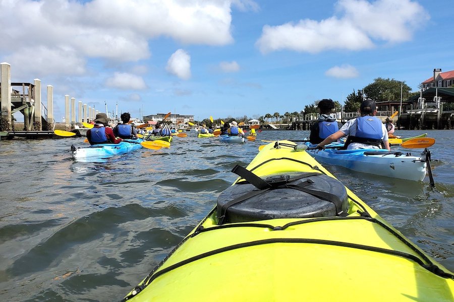 people row in tandem kayaks with a coastal expeditions program through Shem Creek