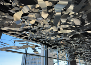 A stainless steel mobile art installation is attached to the roof of the South Carolina Aquarium and is comprised of hundreds of wave-like metal pieces