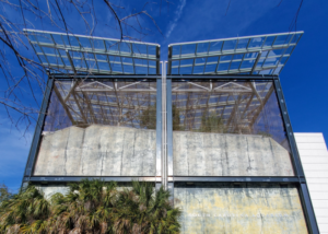 Looking up at the exterior of the South Carolina Aquarium, the top of a jagged wall is highlighted in red to show the elevation pattern of the state from west to east
